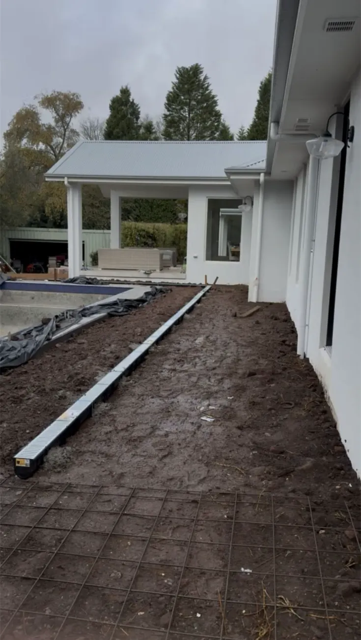New channel drain installed beside a house and pool